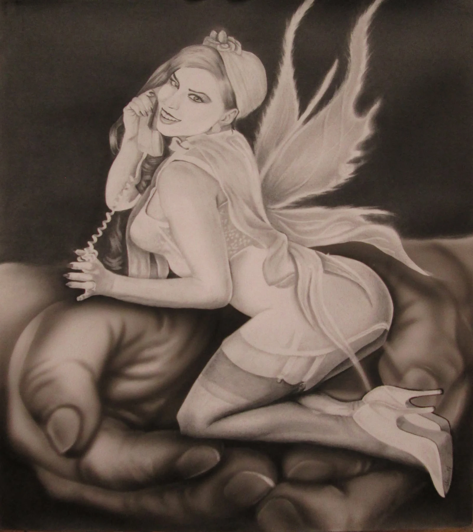 Fantasy figure with fairy wings speaking on a telephone while seated in an open hand